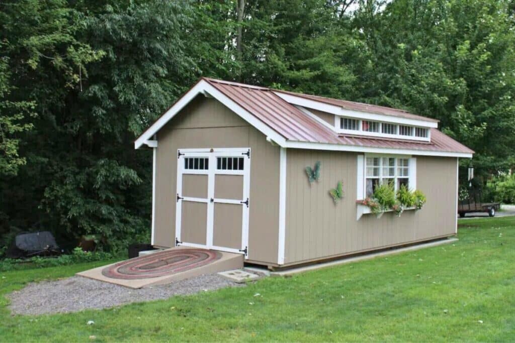 Beige Shed with ramp and windows with planter box on gravel