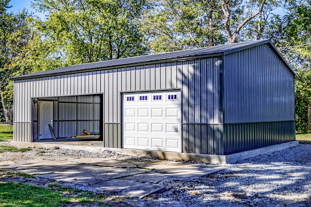 Side view of gray Northedge metal garage with white garage door and open bay