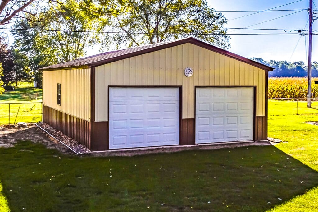Tan and brown two-car metal garage with white garage doors and side door
