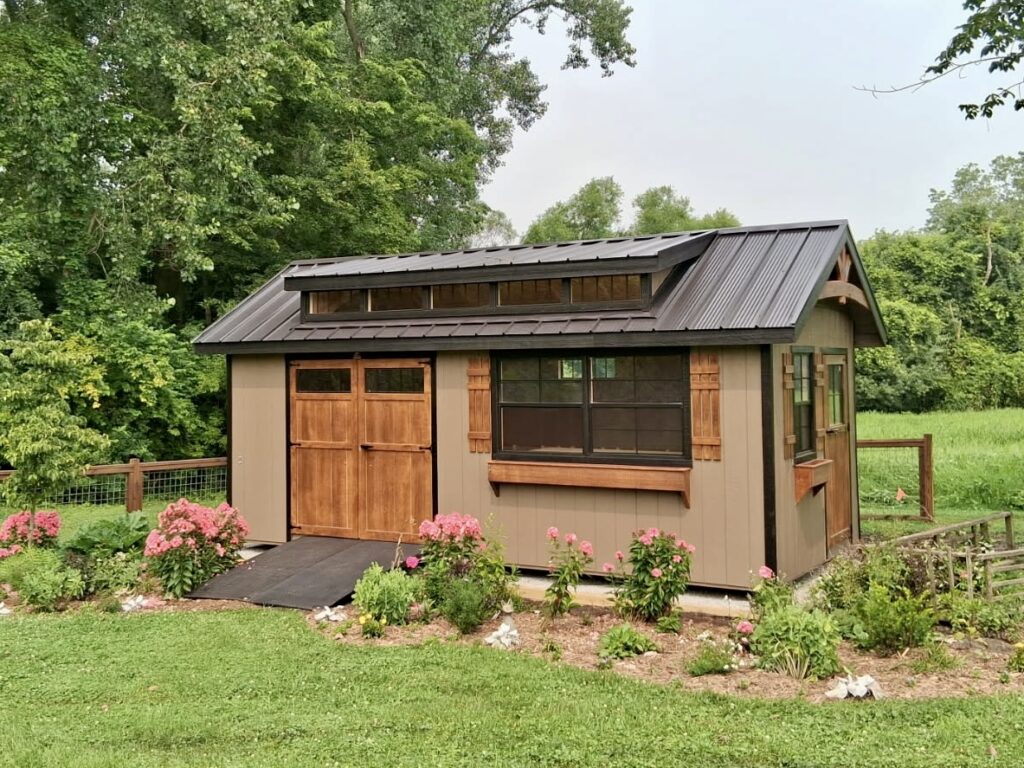10x16 Garden shed elite placed on gravel pad surrounded by flowers